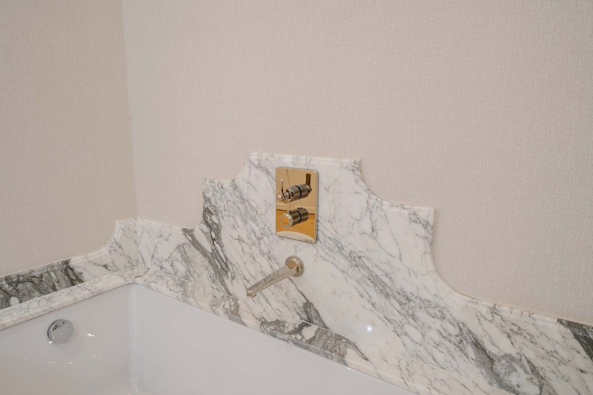 Bañera revestida en mármol con grifería empotrada