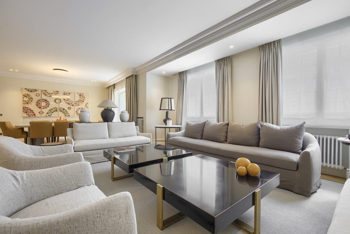 Salón con sofás claros y mesas lacadas